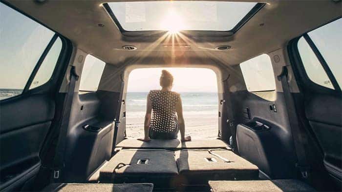 Woman sitting in cargo area of GMC Acadia