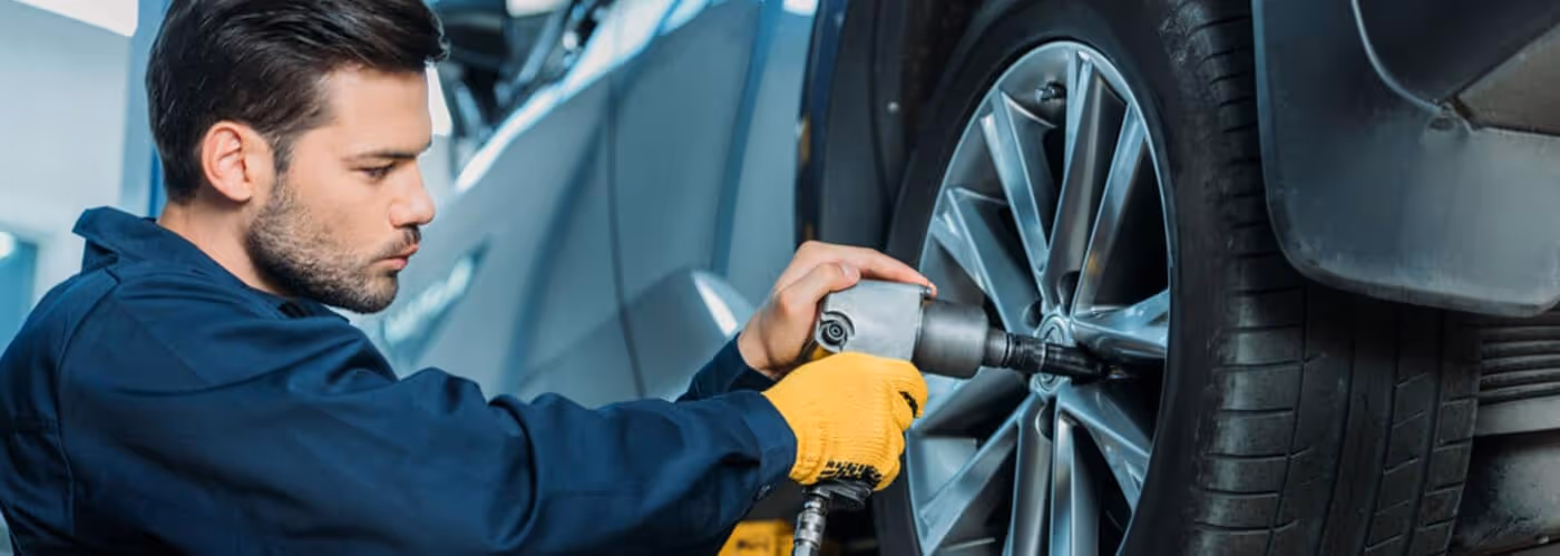 service tech rotating a car tire