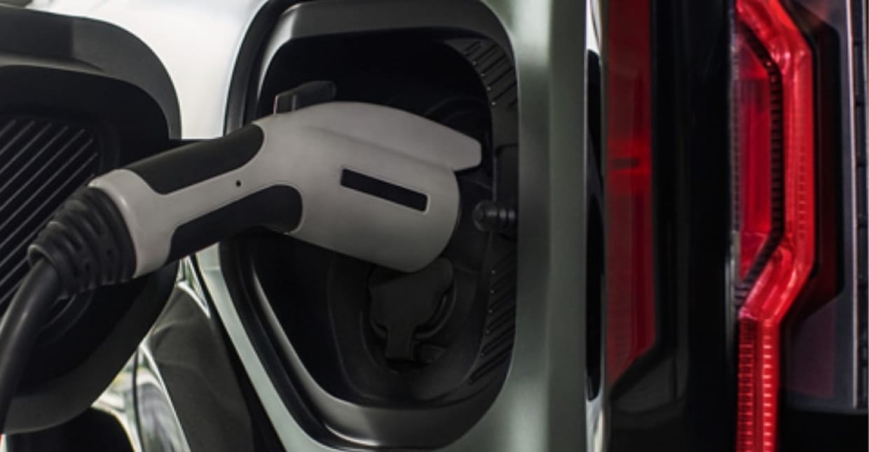 Close up of charging port with charger plugged in on a GMC Hummer EV SUV