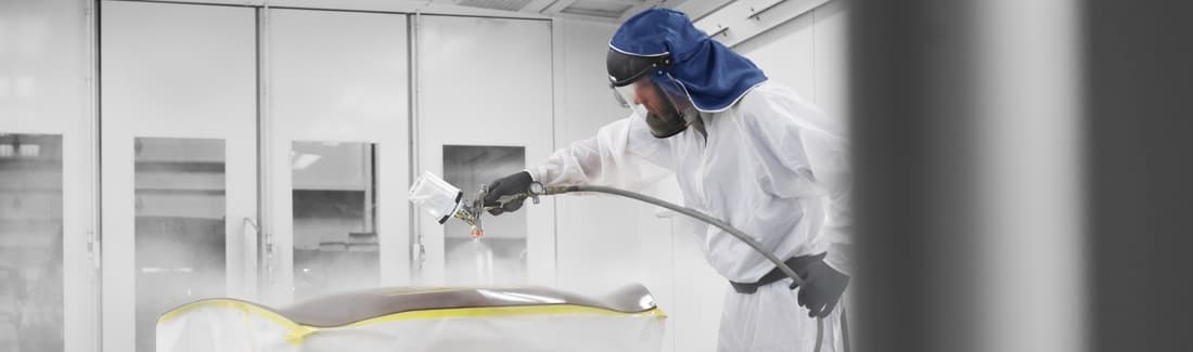 A body shop technician painting a vehicle
